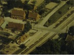 Udsnit af Laurbjerg 1955. Jernbaneoverskæringen med banehuset(Nørregade 1) Det stor hus med forretningsvinduer i kælderen(Nørregade 4) fungerede i mange år som slagterforretning
