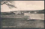 Amtmand Hoppes Bro blev indviet den 4. December 1905. Det ser ud som om, motivet er taget kort efter indvielsen, da skråningerne på venstre side ser ret nøgne ud. Foran broen ses stedet, hvor man tidligere kunne tage prammen over Gudenåen.